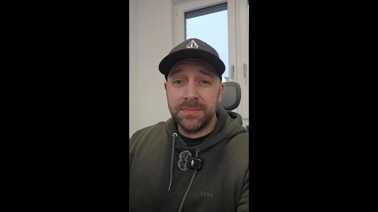 Klarer Screenshot des Moderators mit Kappe und Ansteckmikrofon, erklärt Chip- und Gaming-Themen