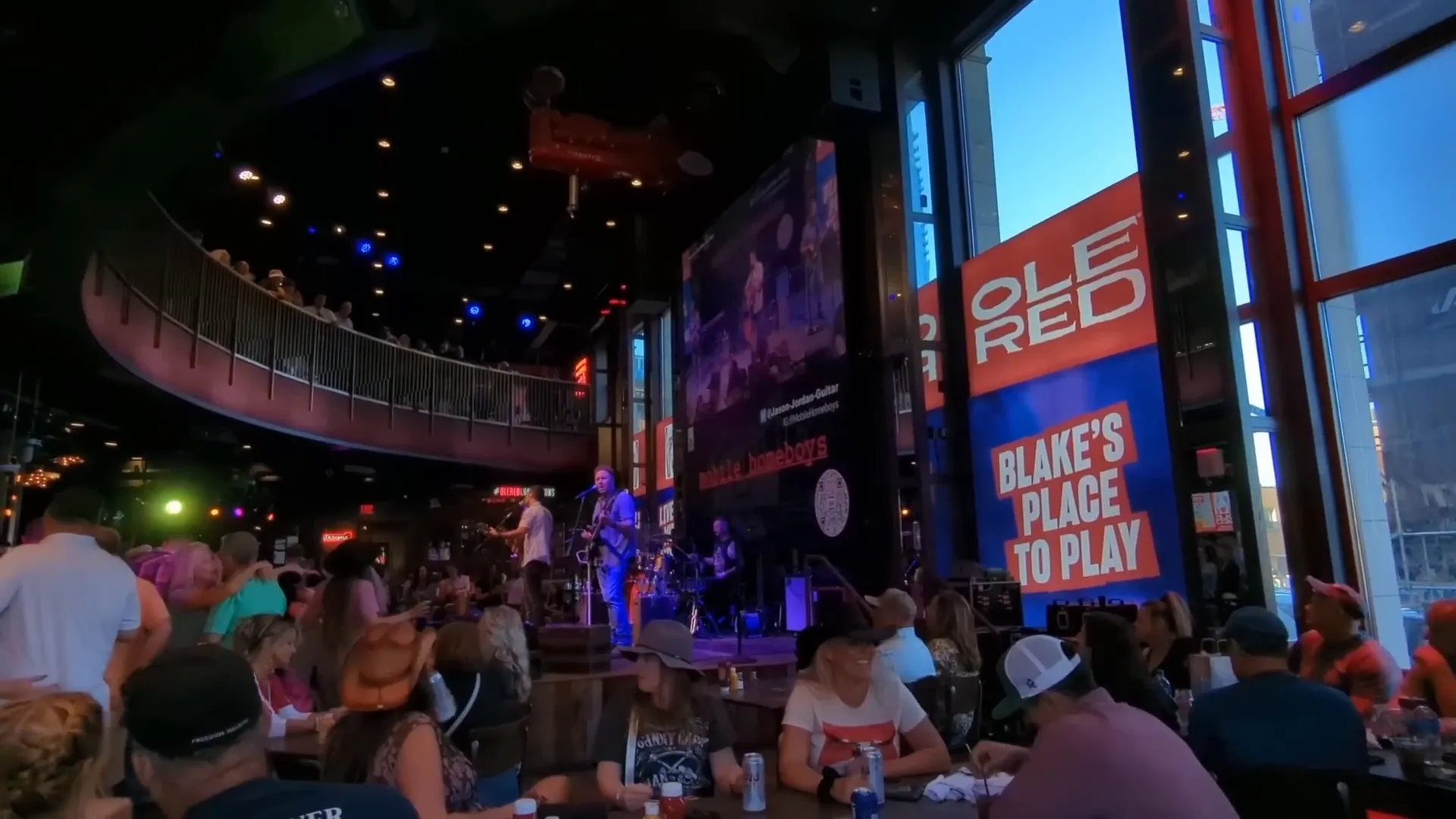 Lower Broadway at night with live music and bustling crowds