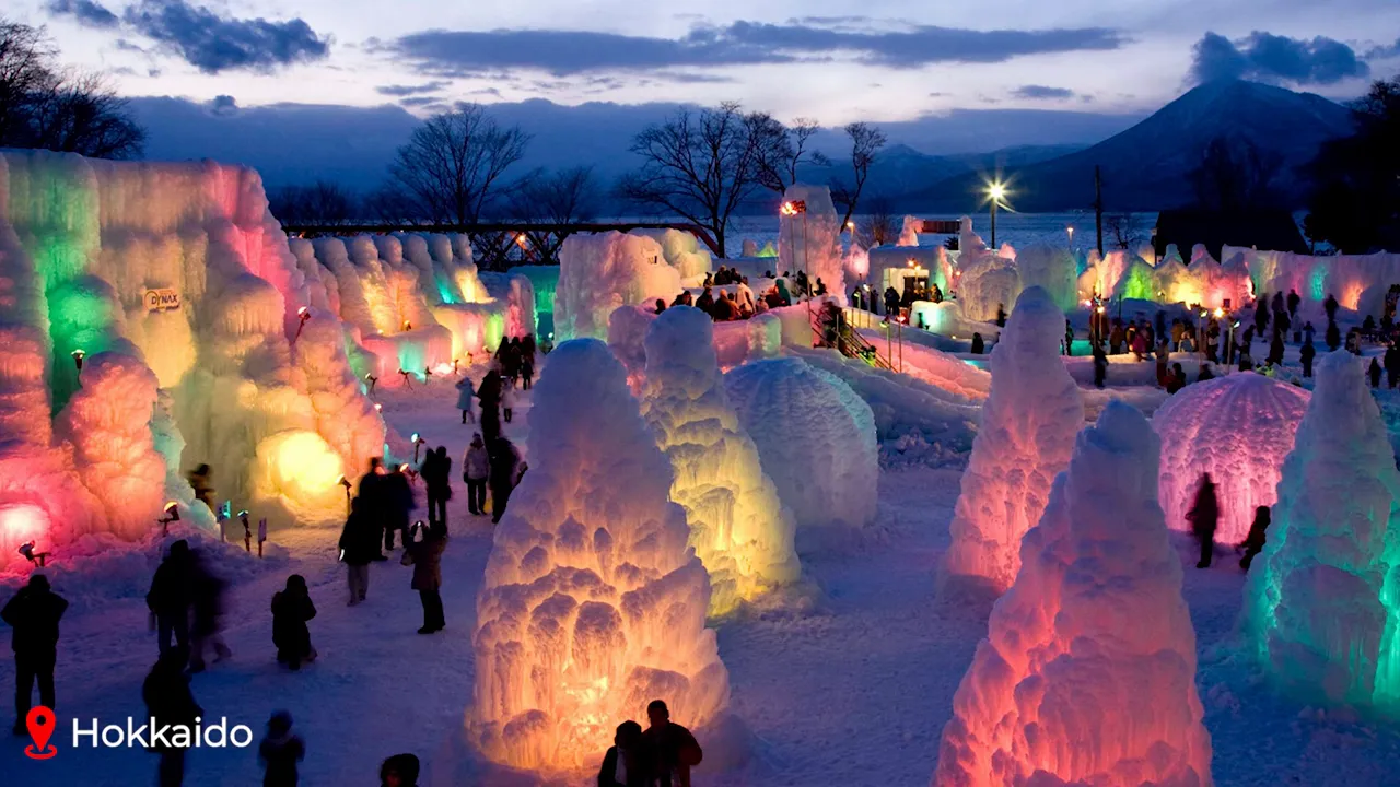 Colorfully lit ice and snow sculptures at the Sapporo Snow Festival with visitors at dusk