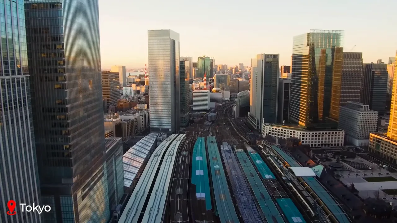 Aerial view of Tokyo train station platforms and surrounding skyscrapers at sunset