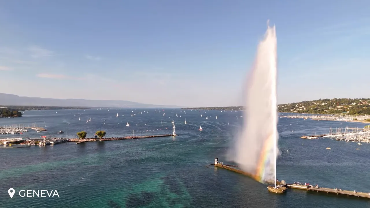Jet d'Eau fountain shooting high above Lake Geneva with marina and sailboats in the background