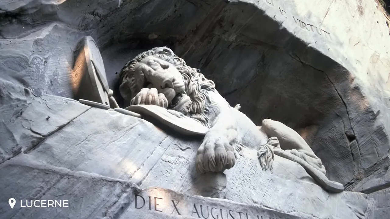 Close-up detail of the Dying Lion of Lucerne carved into the sandstone, showing the lion’s face and paw with part of the inscription