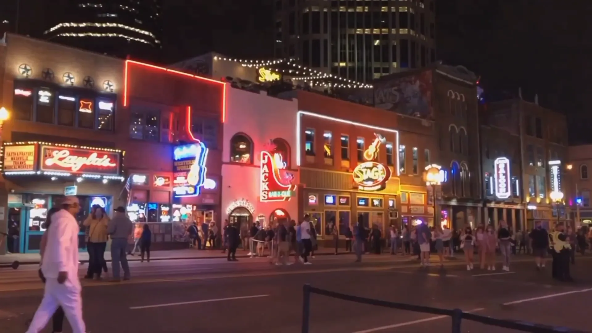 Wide shot of Broadway honky tonks and downtown Nashville skyline