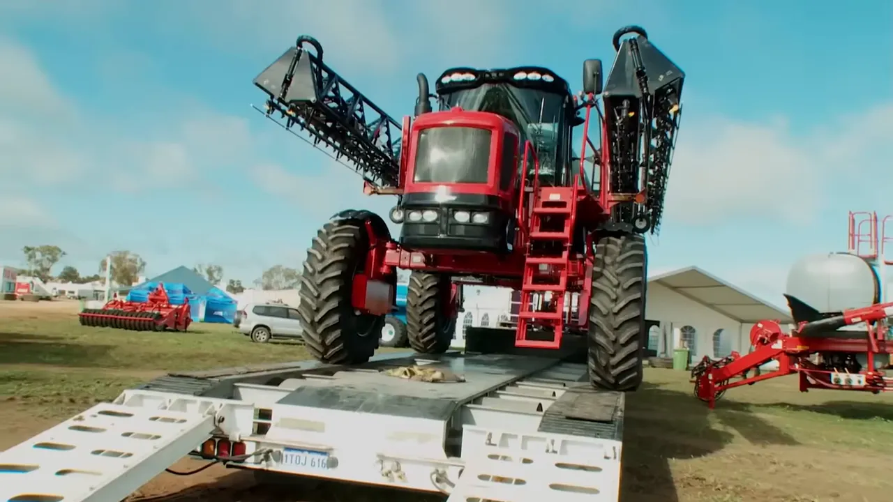 Trucker easing a machine onto the trailer with millimetre precision