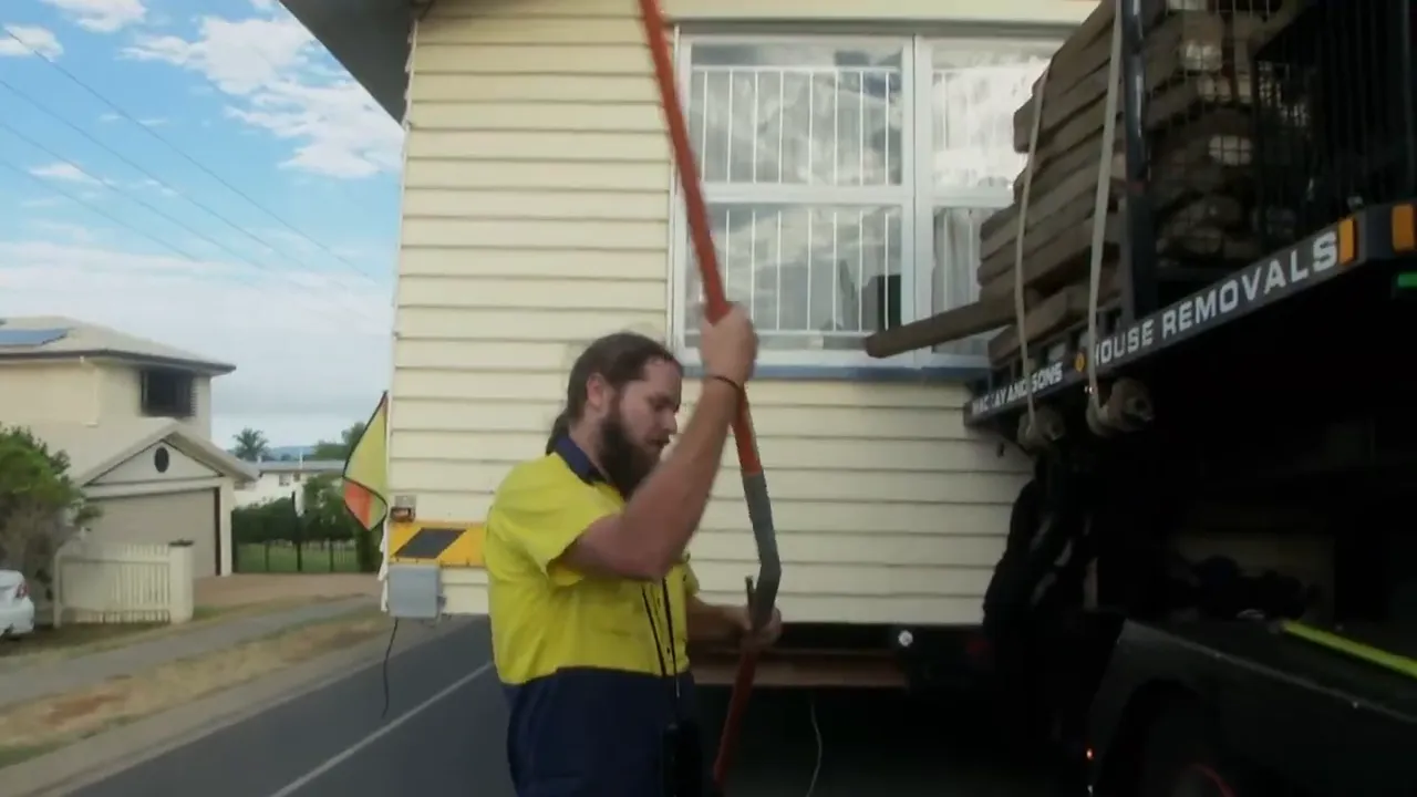 Roof inches from a live powerline — team prepares to lift lines