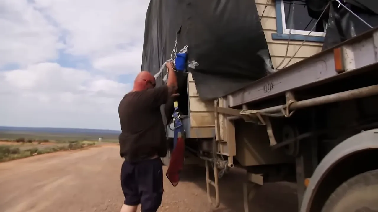 Kurt checking shredded tarp flapping above the sight hut