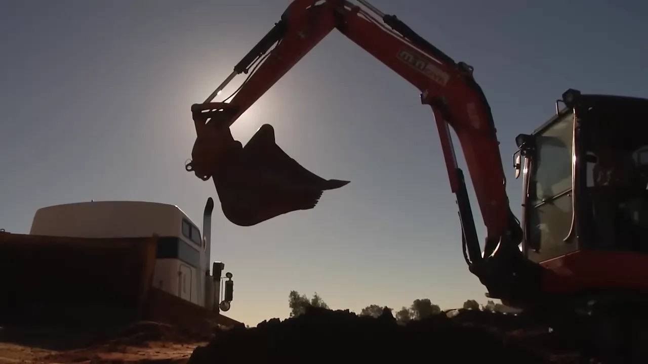 Workers shovelling premix after hydraulic failure