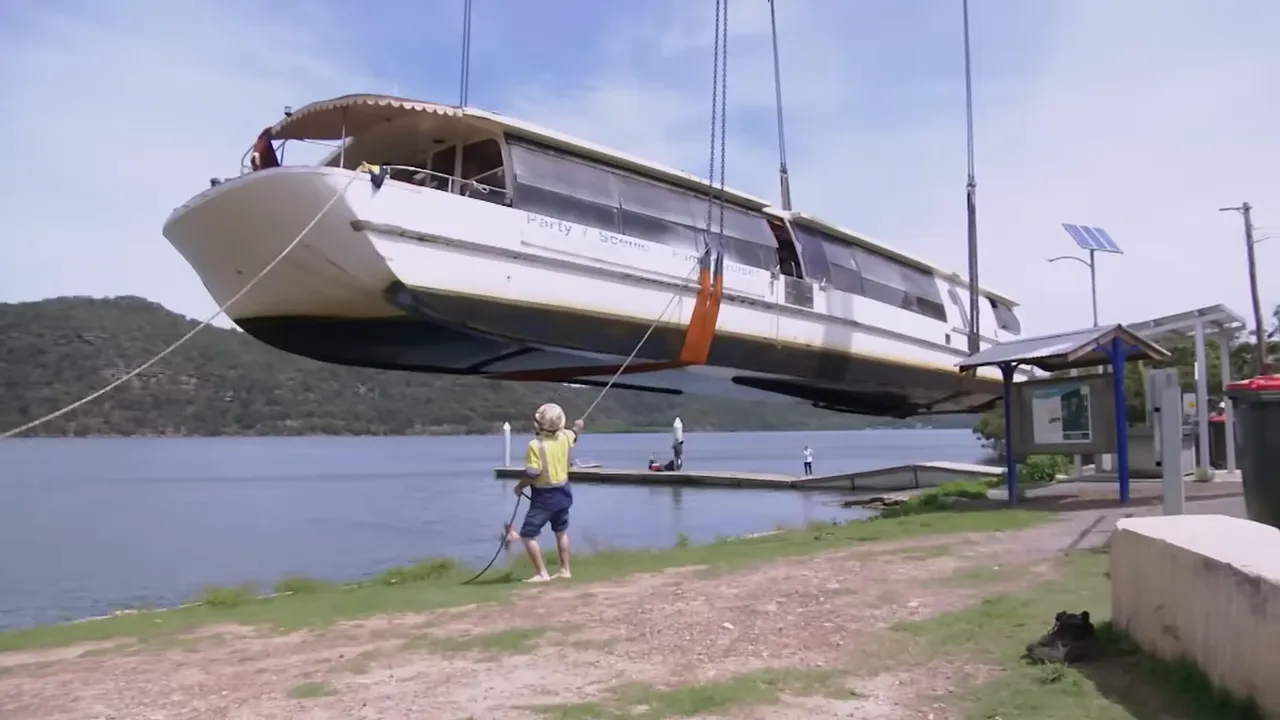 Crew lifting the river cat with slings positioned near the ribs