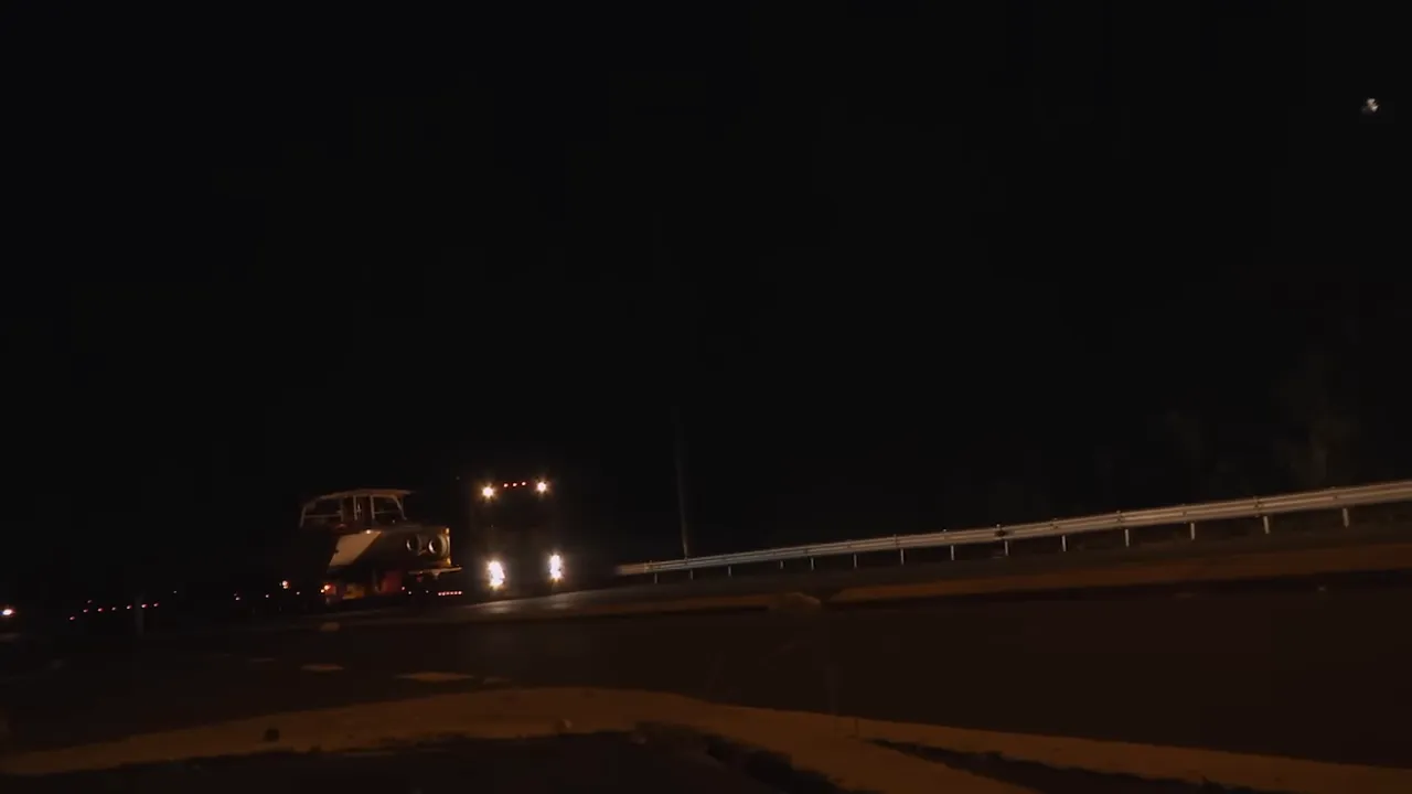 Night convoy with pilot cars guiding the oversized load