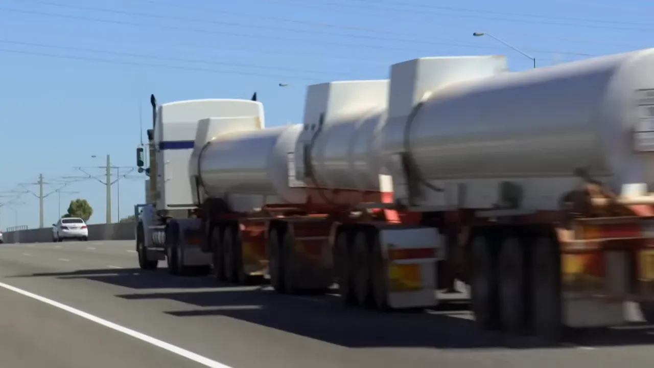 Triple road train on highway with dust