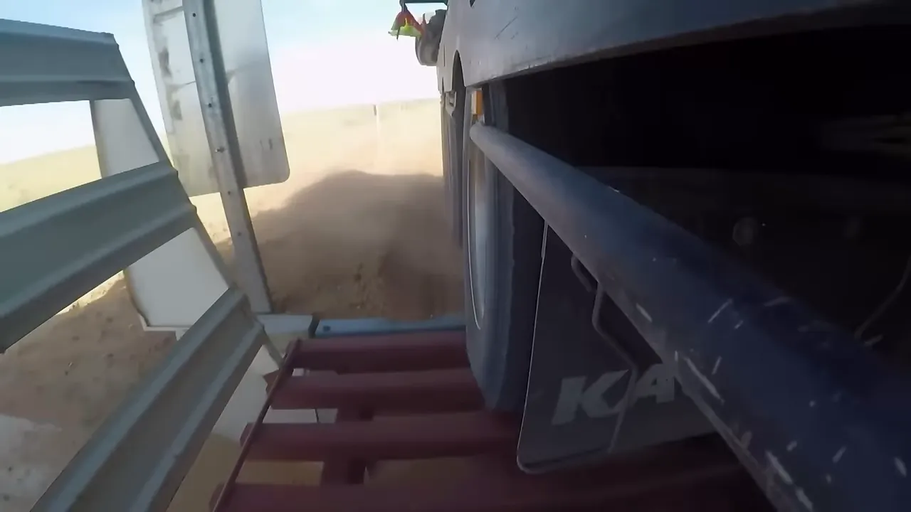 The duo driving slowly along corrugated dirt with heavy dust