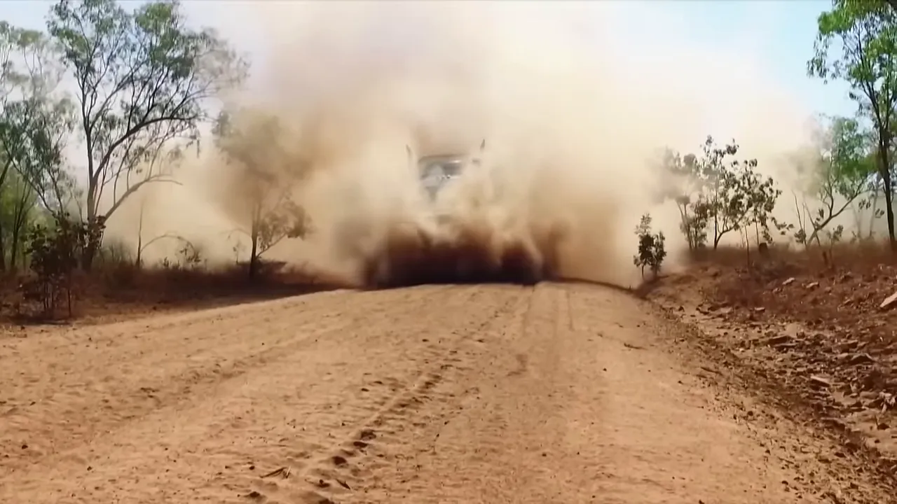 Truck driving through a massive bulldust patch