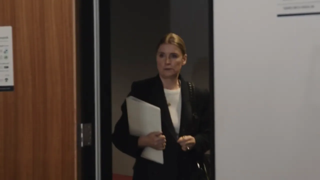 Person entering a hearing room holding a folder