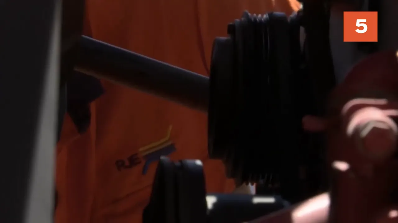Mechanic inspecting missing idler pulley on truck engine
