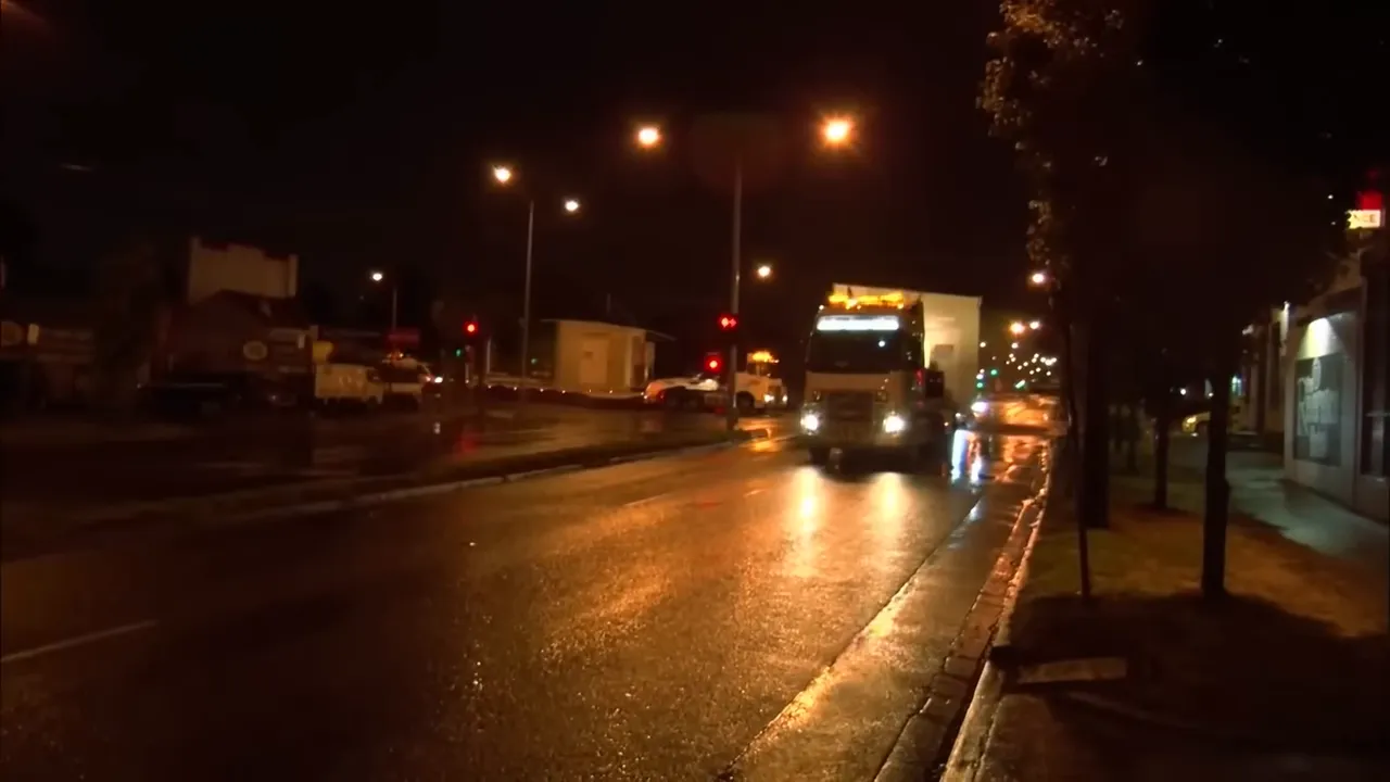Truck approaching tree-lined city street, trees close to load height