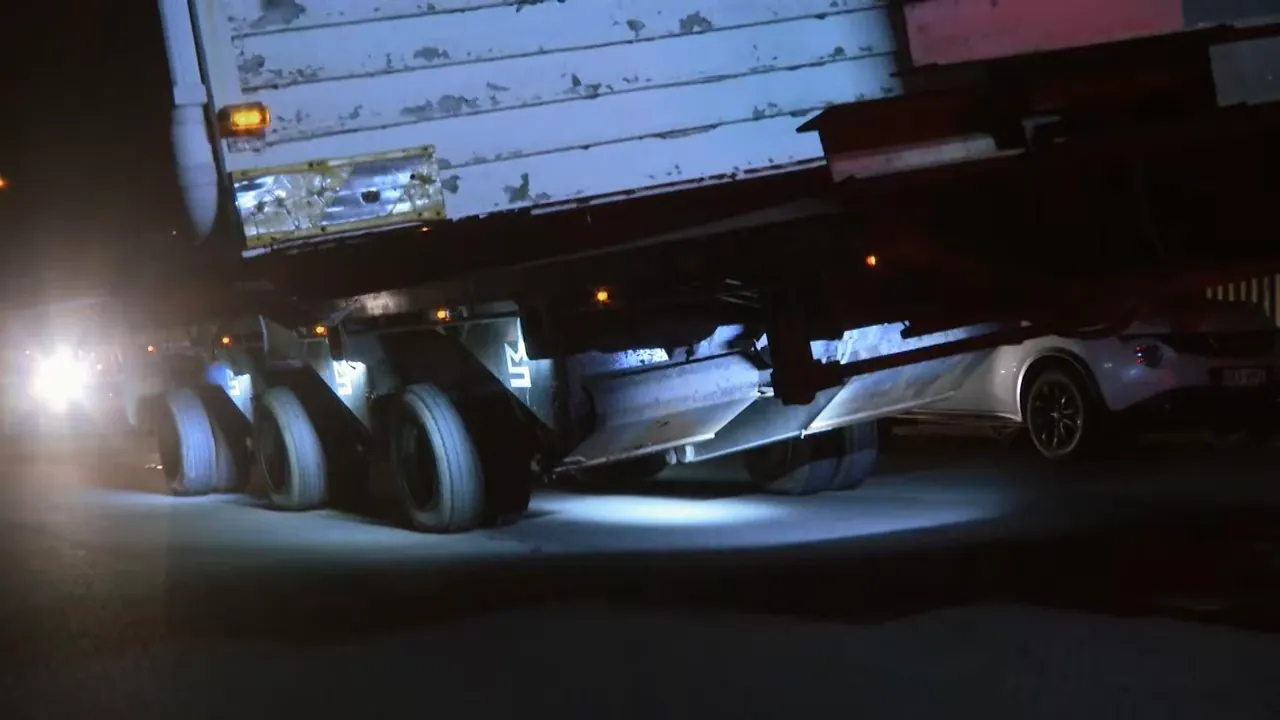 Hydraulic trailer lifting and tilting the load to clear tight spaces