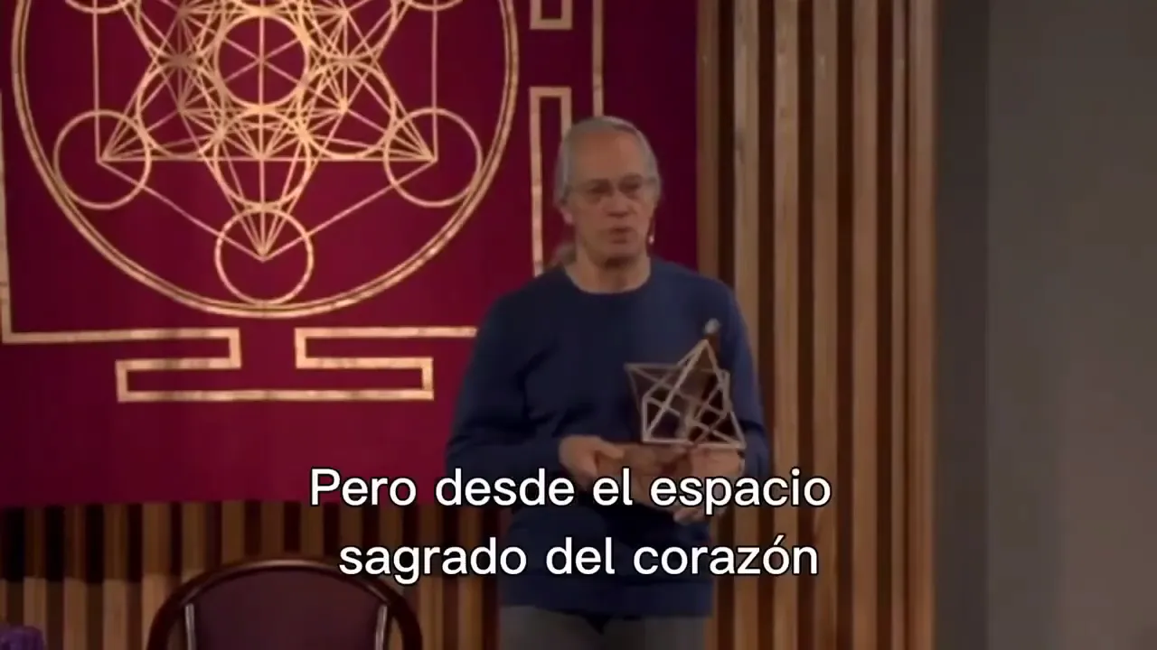 Ponente en escenario sosteniendo una figura geomtrica subttulo visible Pero desde el espacio sagrado del corazn