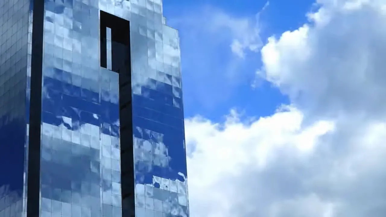 EDR, MDR y XDR: Edificio corporativo con cielo azul y nubes, simbolizando infraestructuras empresariales