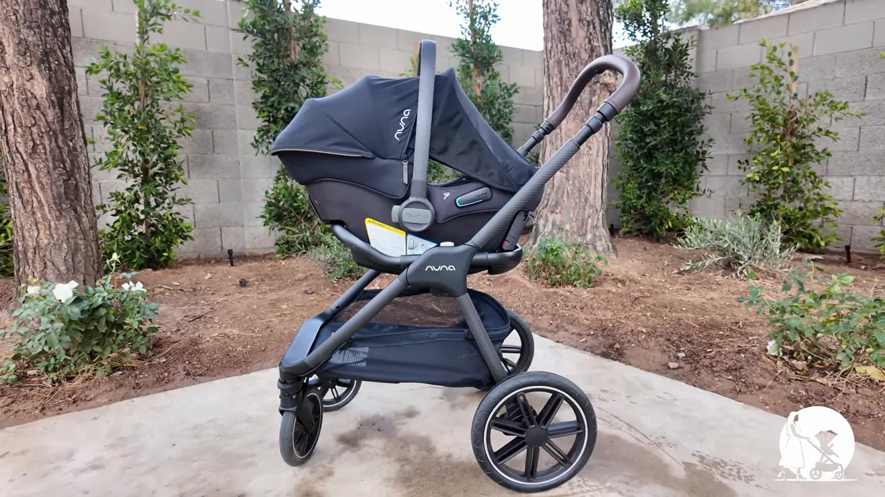 Clear side profile of Nuna PIPA URBN infant car seat installed on Nuna TRIV LX stroller showing canopy and frame