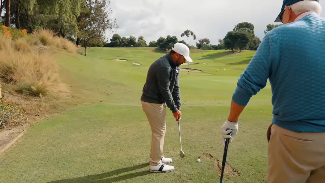 Golfer at address with coach observing, showing posture and ball position from a face-on view
