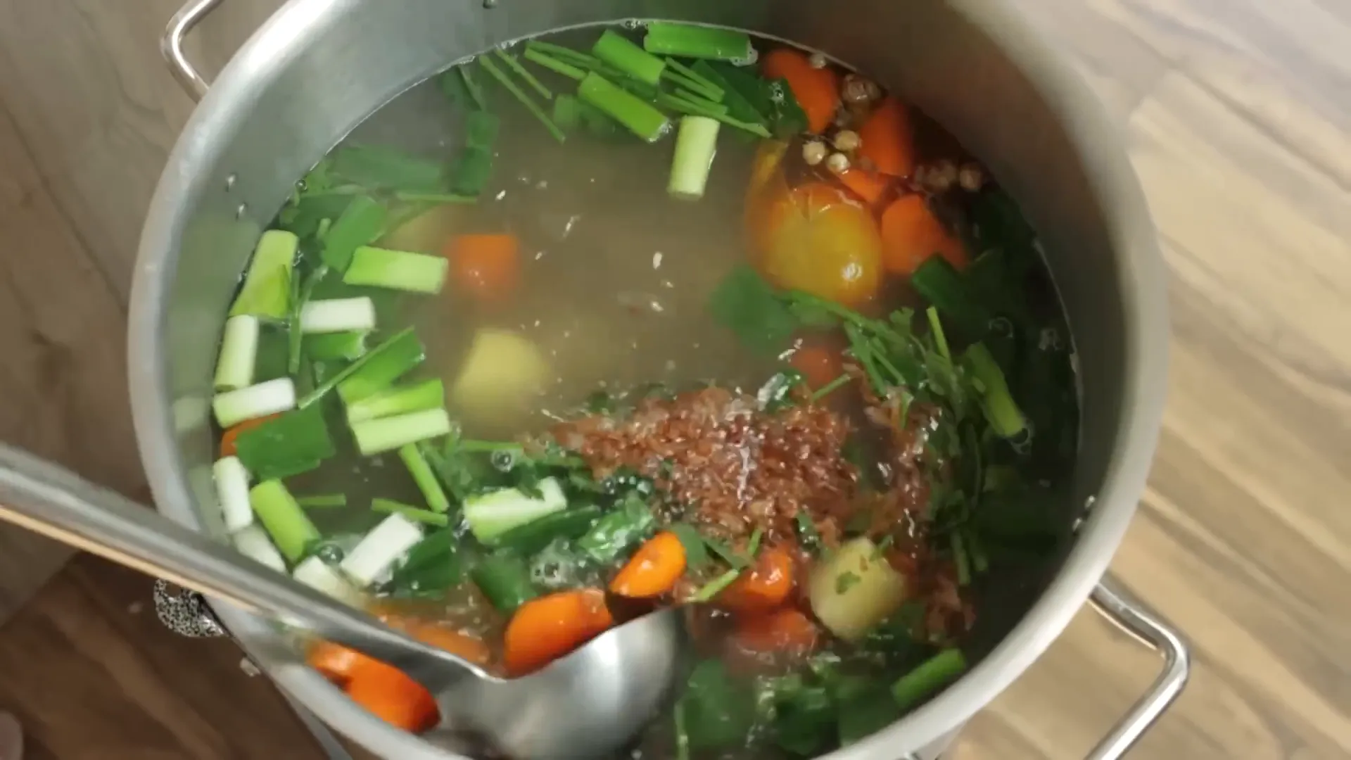 Sup iga siap disajikan dengan taburan daun bawang, seledri, dan bawang goreng