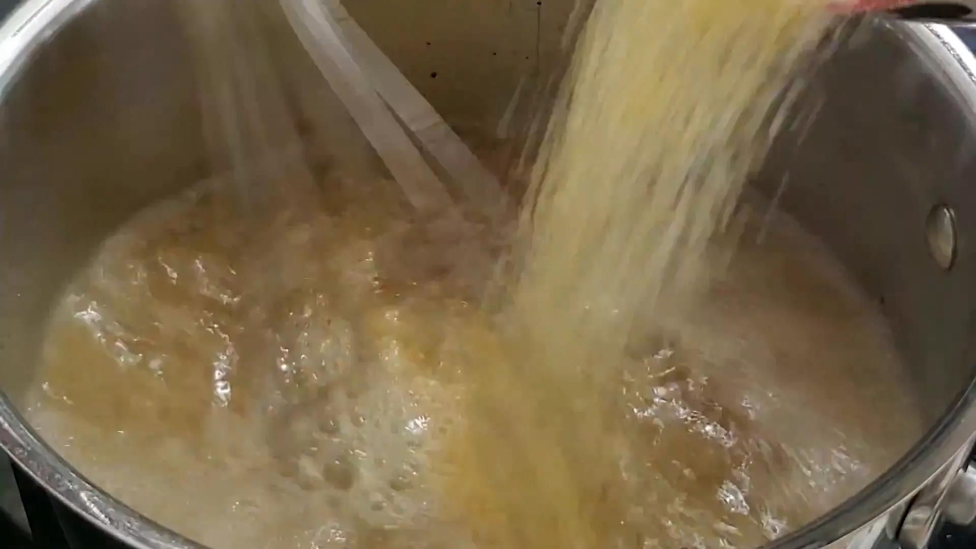 Whisking corn grits into boiling stock.