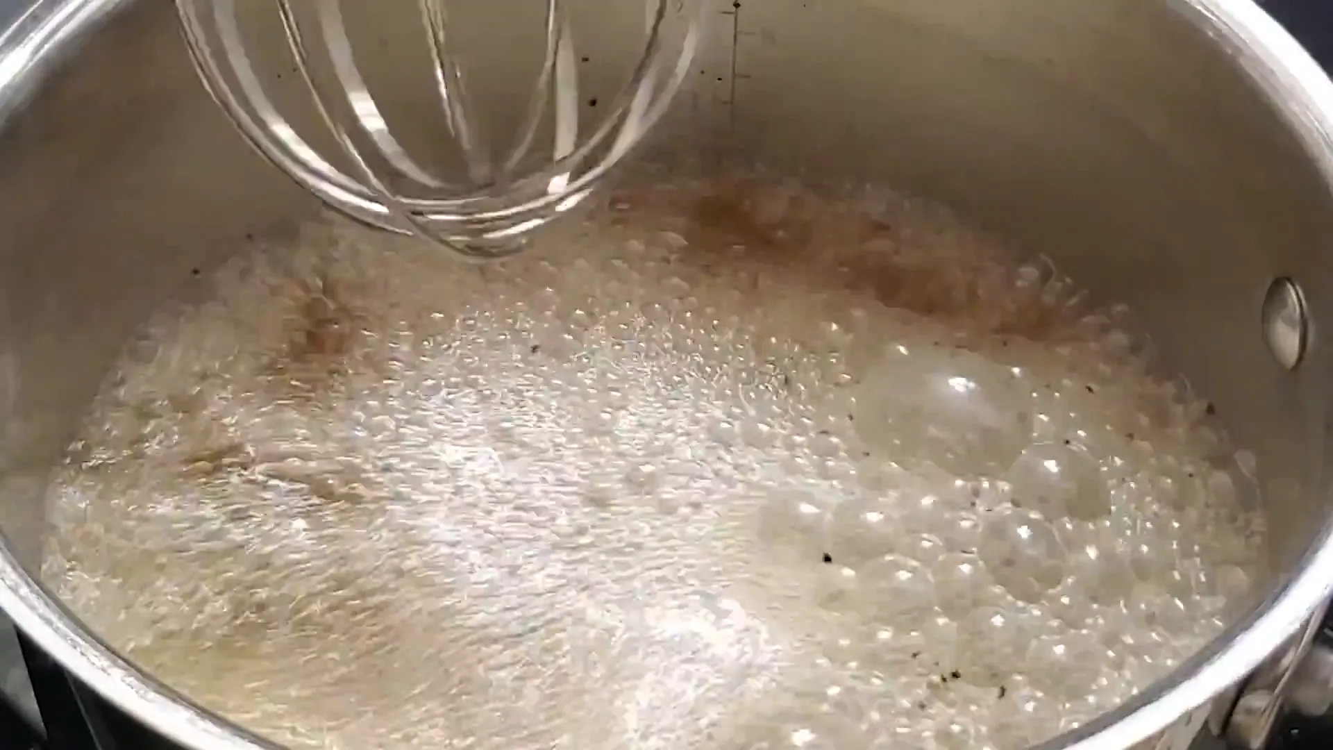 Bringing chicken stock to a boil.
