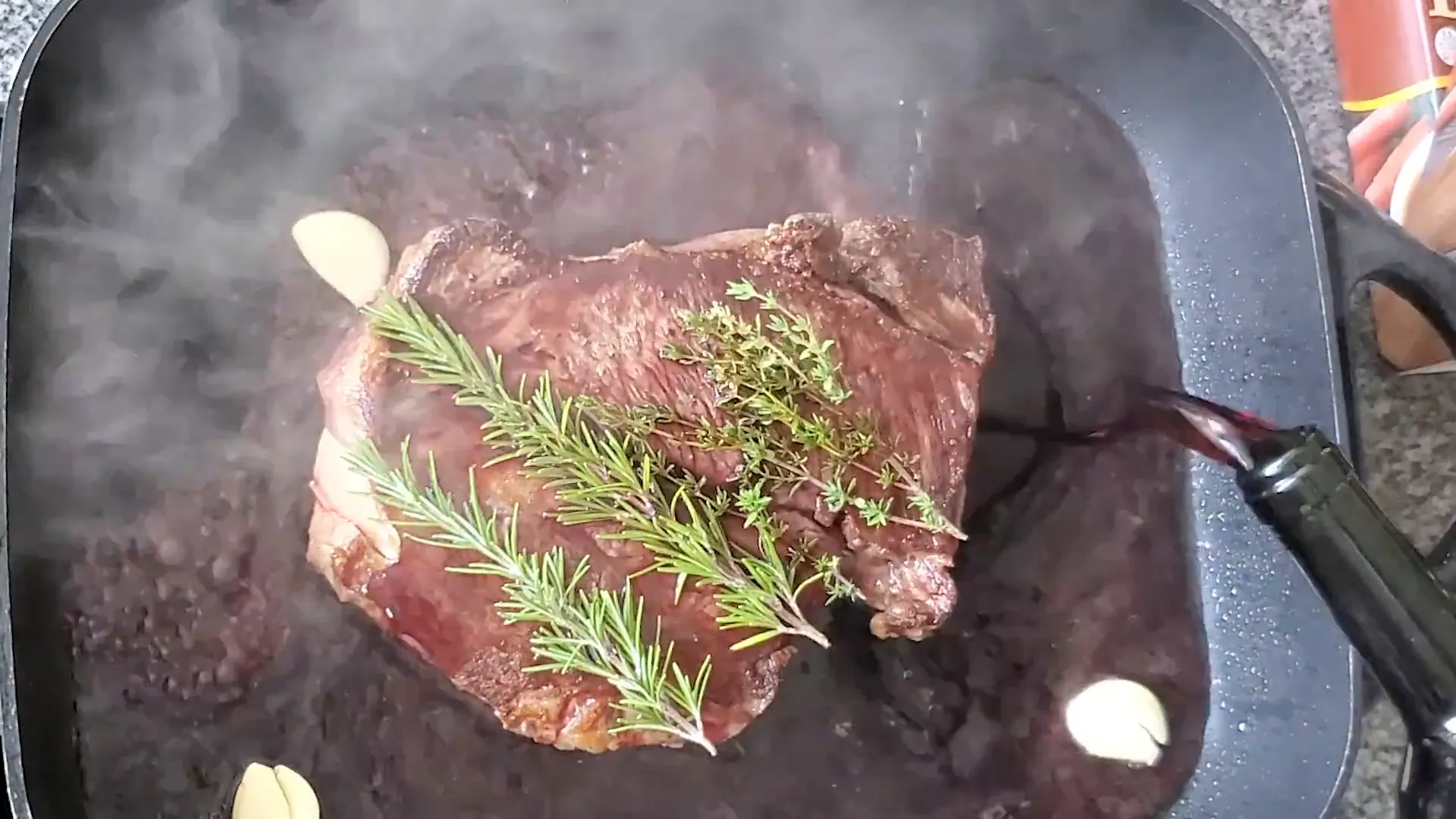 Pouring red wine over the roast.
