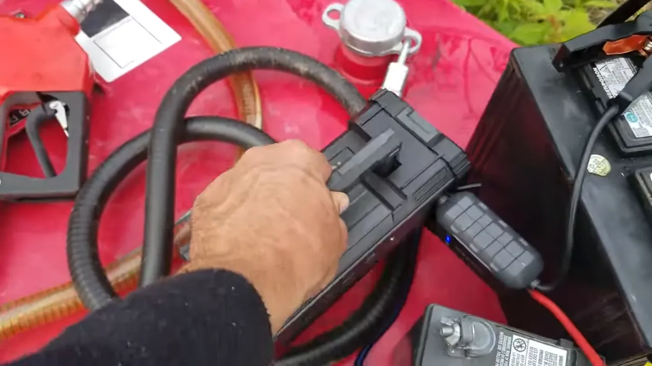 Off grid life - portable jump pack, battery, cables, and fittings laid out on red equipment