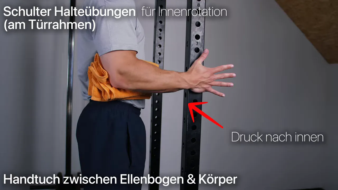 Arm am Körper mit Handtuch zwischen Ellenbogen und Rumpf bei Außenrotations Halteübung am Rahmen