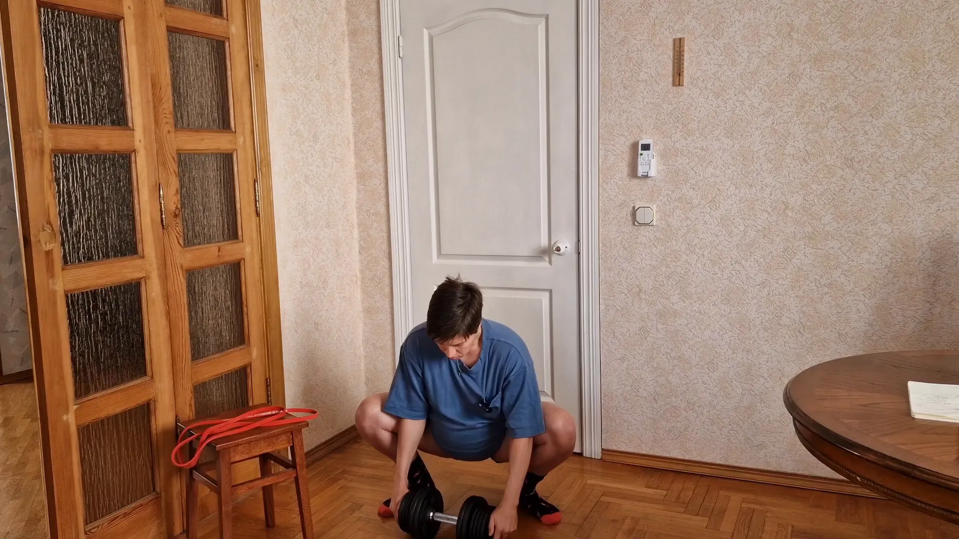 Holding a weight plate during deep squat stretch