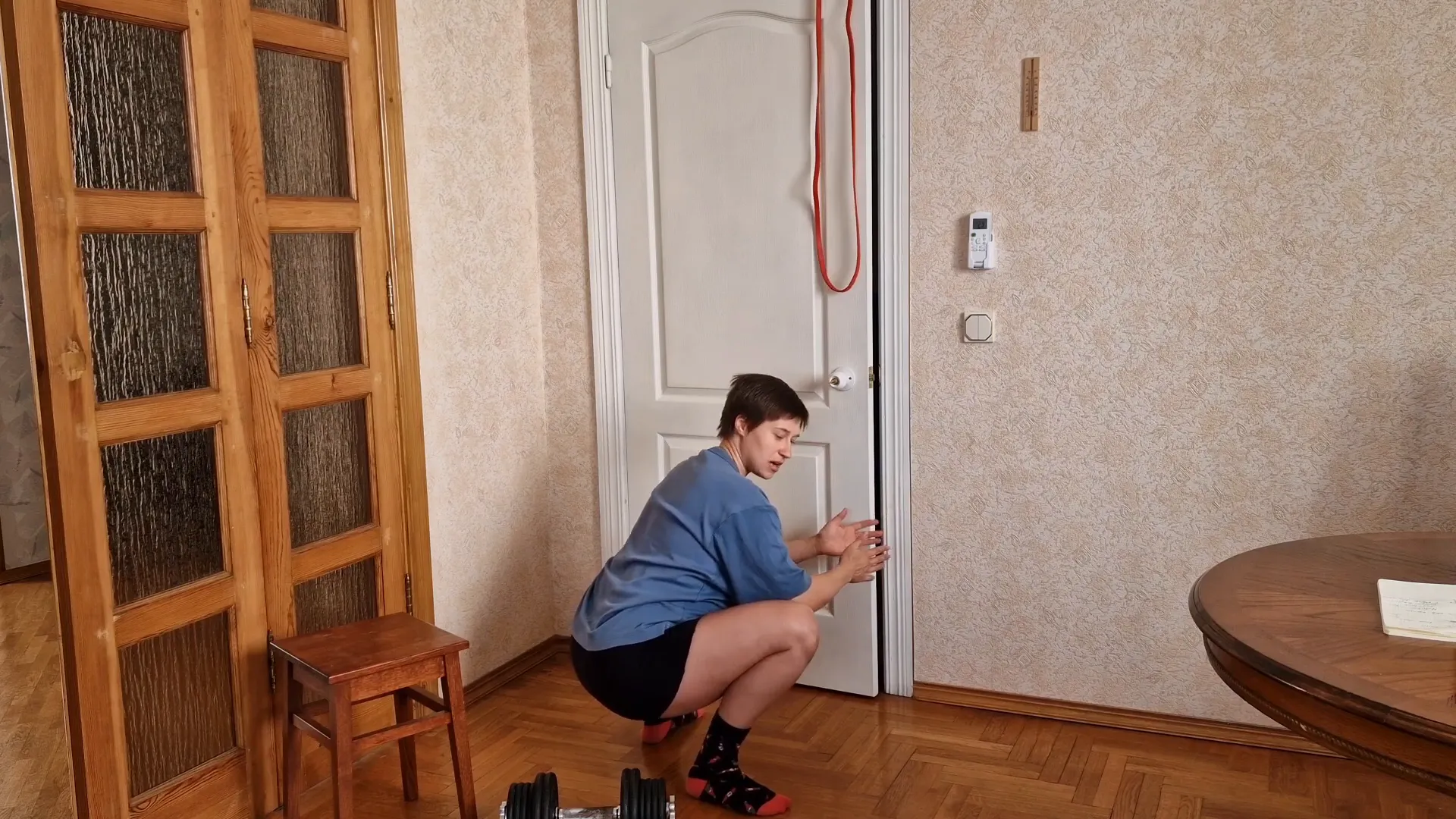 Holding onto band support during deep squat stretch