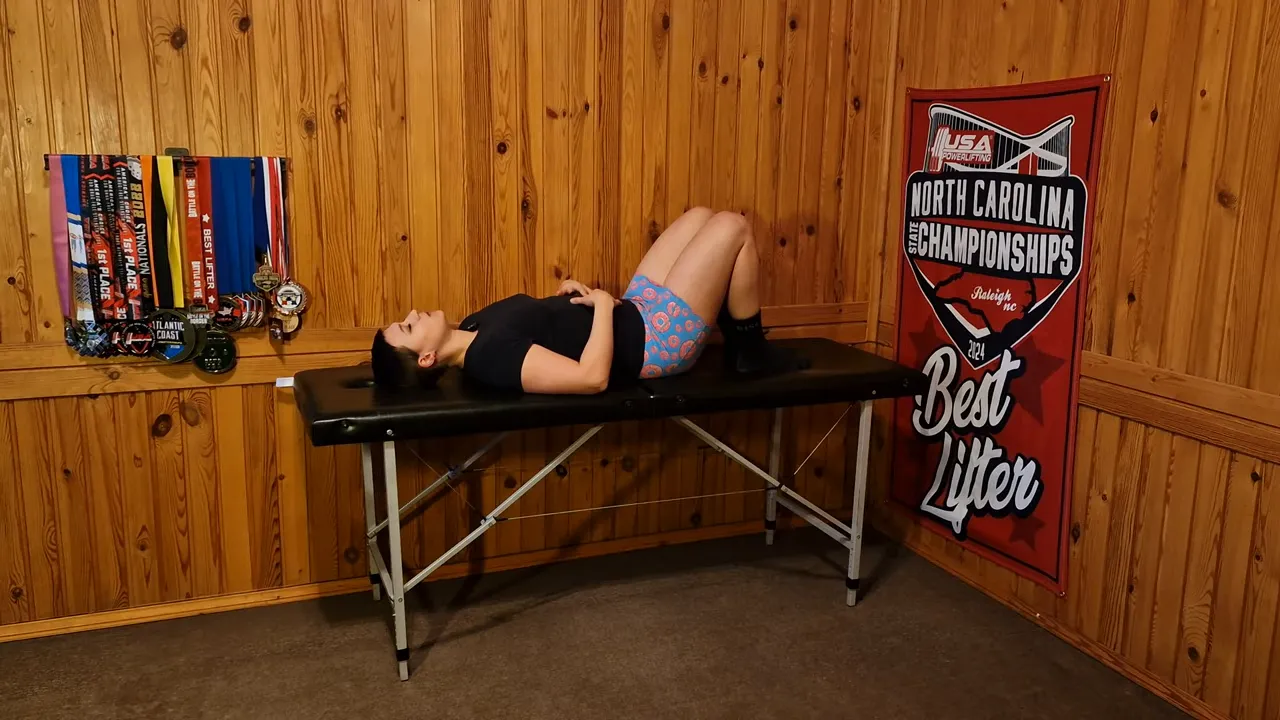 person lying on bench performing belly breathing with hands on abdomen