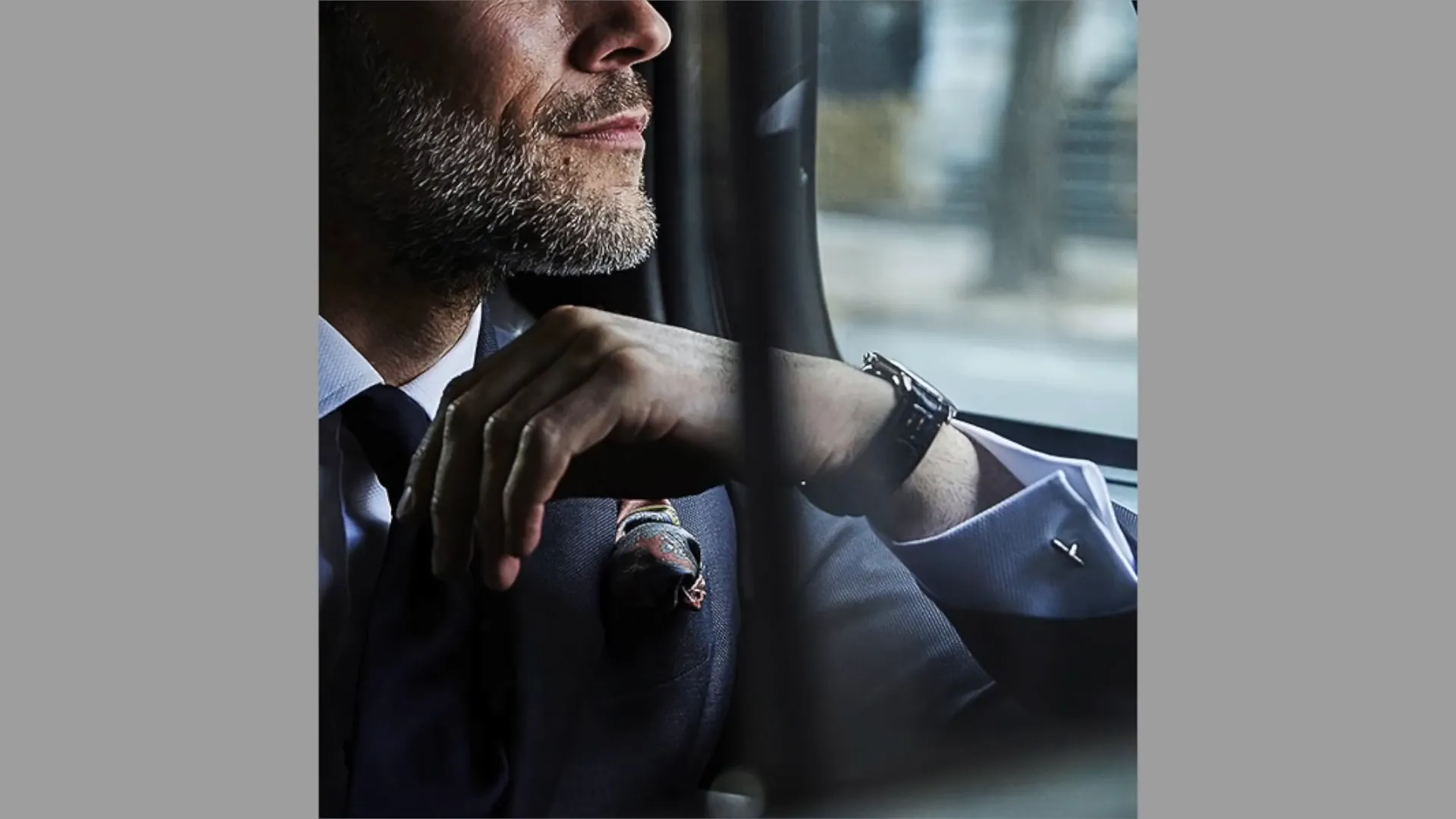 A close-up of suit accessories including a tie and cufflinks