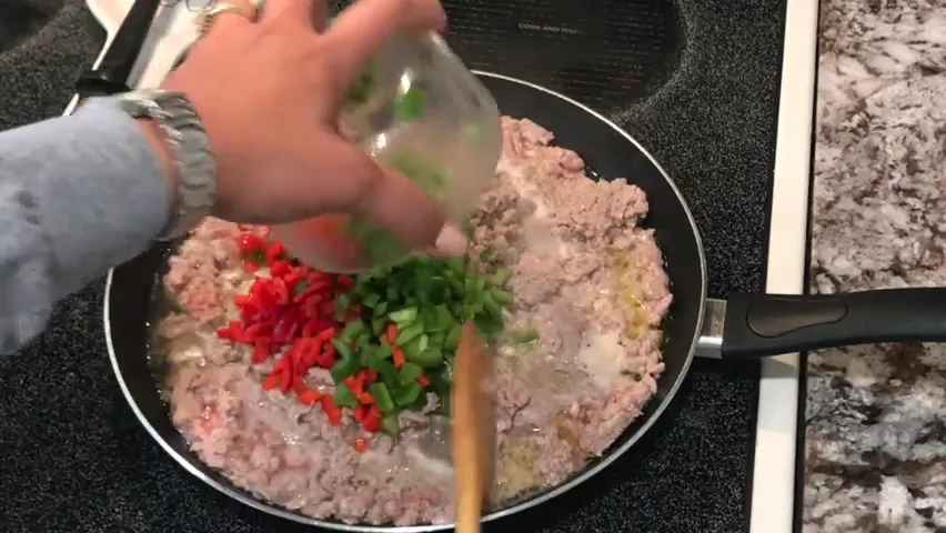 Adding diced peppers and onions to the skillet