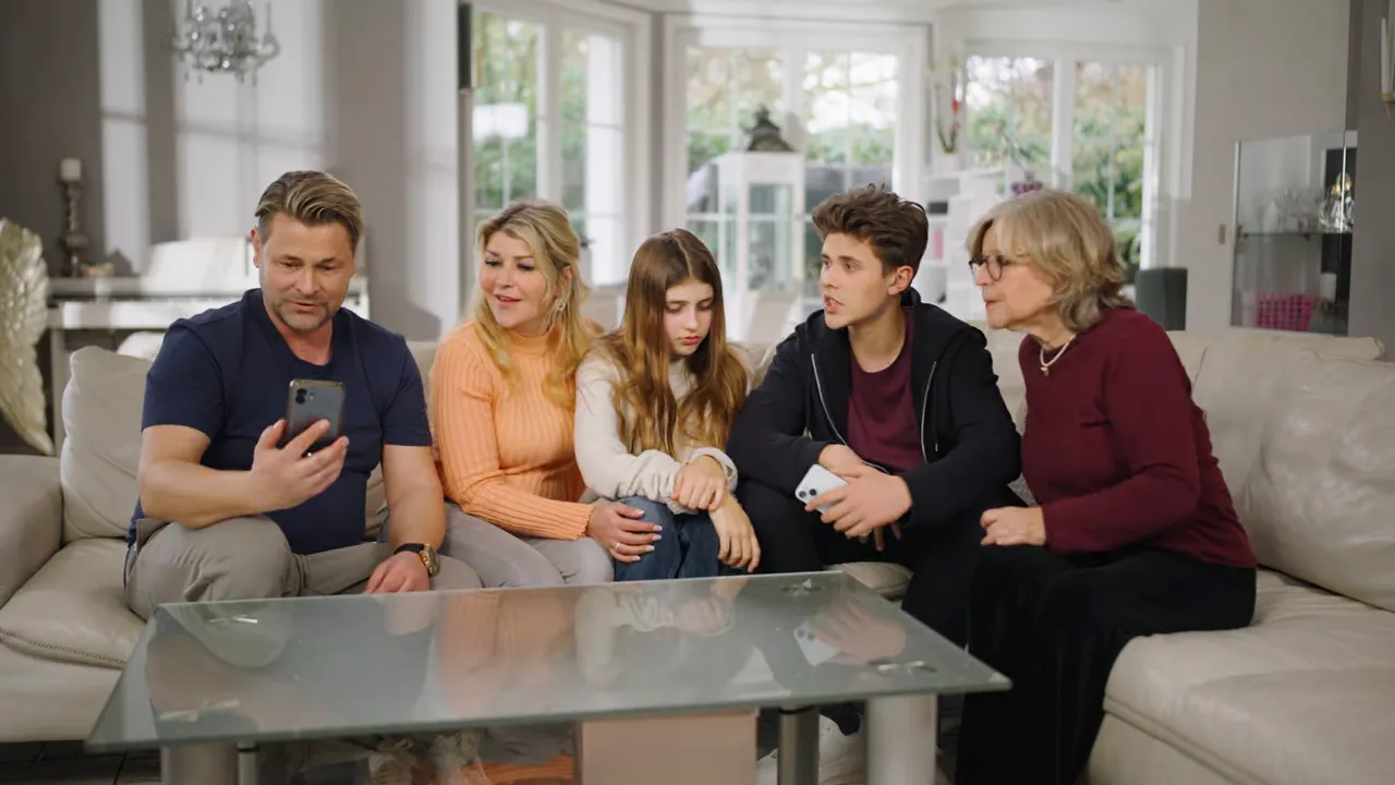 Familie sitzt im Wohnzimmer zusammen und bespricht digitale Sicherheits-Einstellungen im Kontext des DigitalHomeService