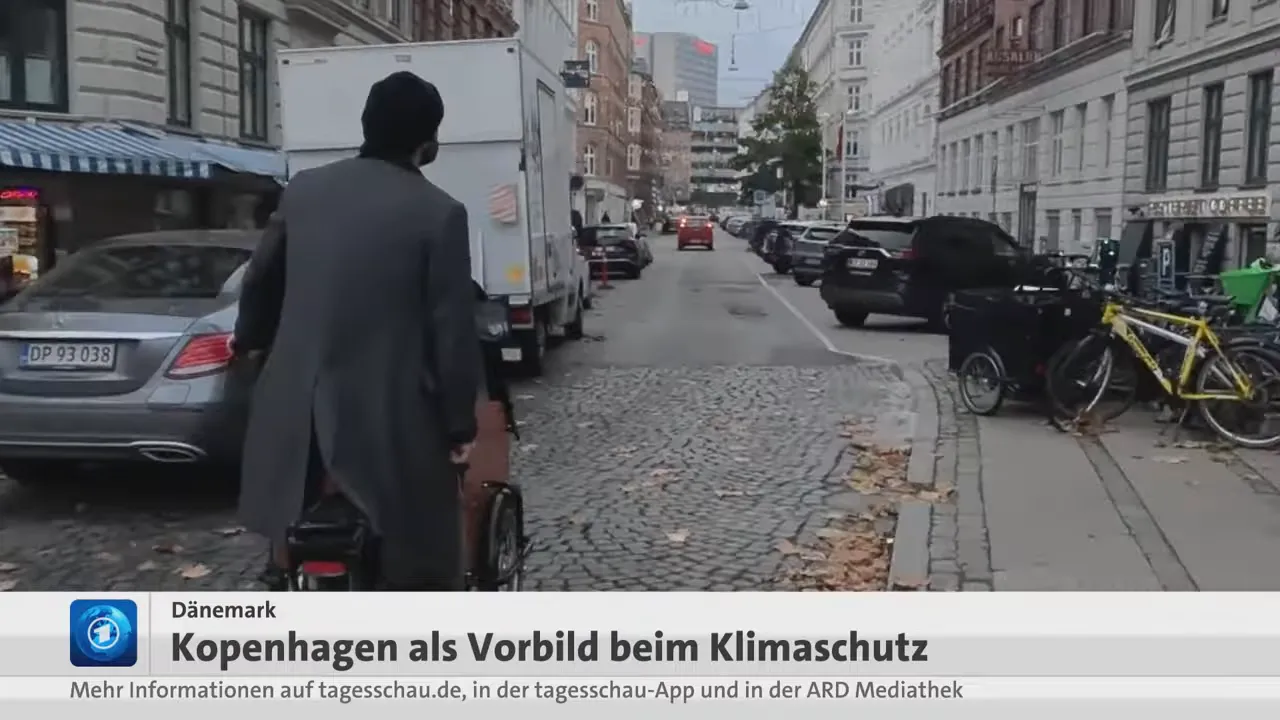 Kopenhagener Wohnstraße mit parkenden Autos, abgestellten Fahrrädern und einem Lastenrad am Gehweg.