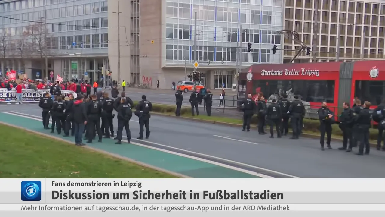 Polizeikette und Demonstrierende auf der Straße in Leipzig mit roter Straßenbahn im Hintergrund