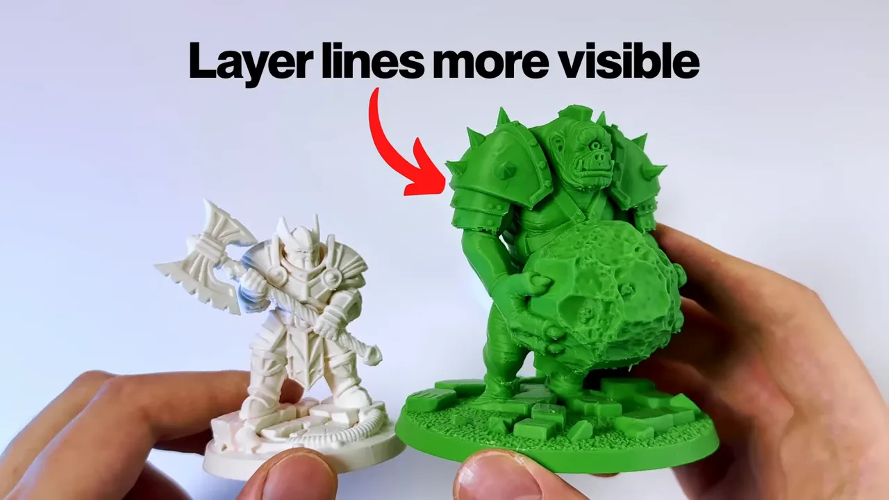 Miniature blanche et modèle vert tenus à la main avec une flèche indiquant que les lignes de couche sont plus visibles sur le modèle vert