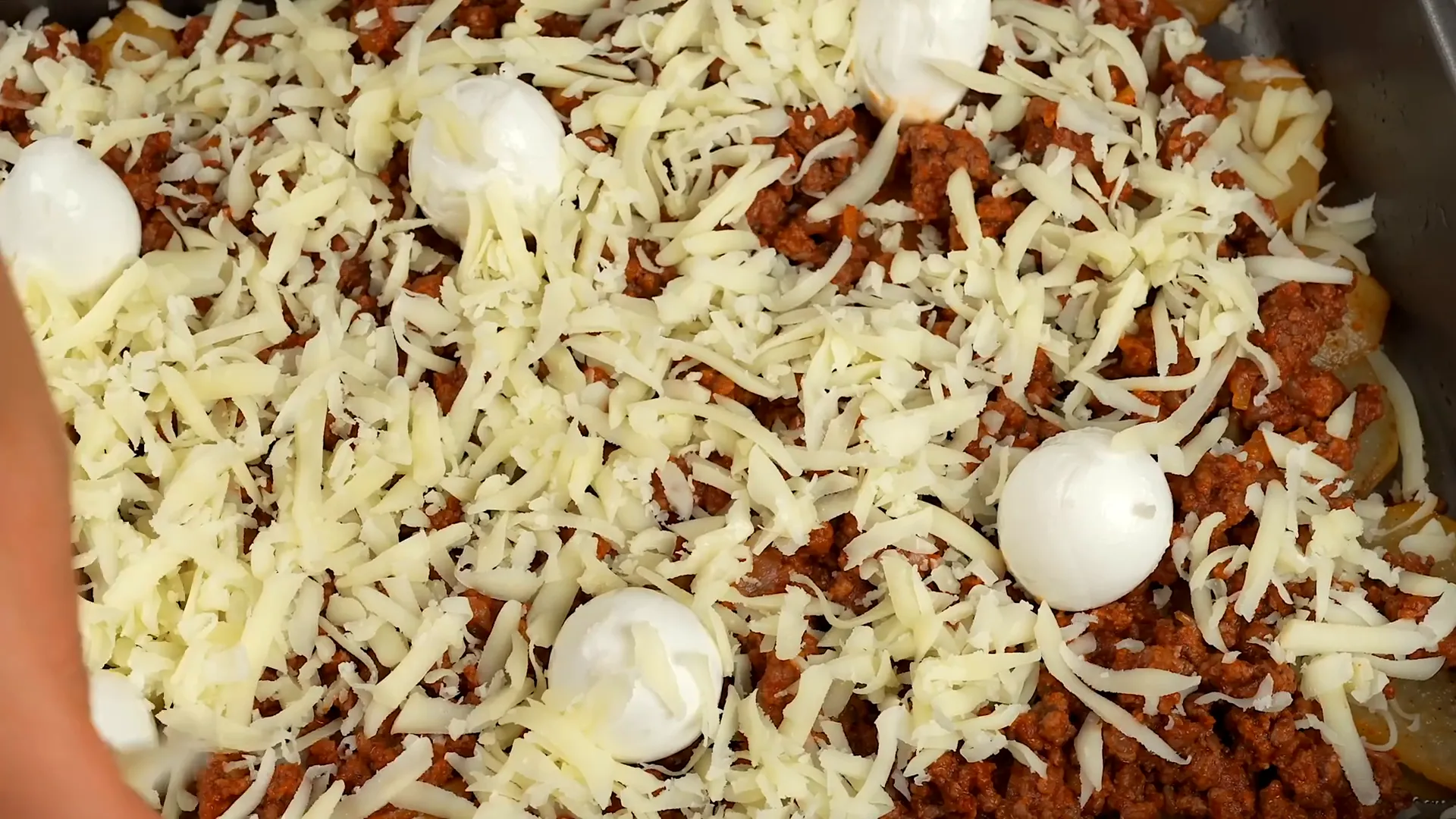 Baking the assembled dish until cheese is browned