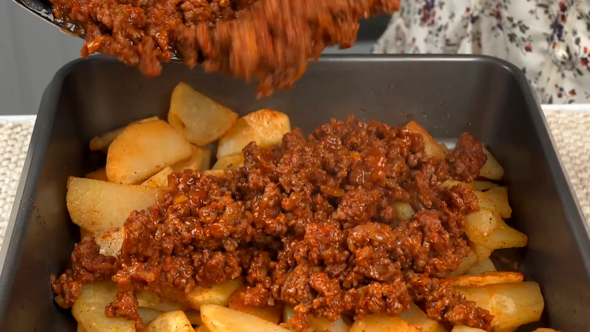 Layering ground beef over baked potatoes