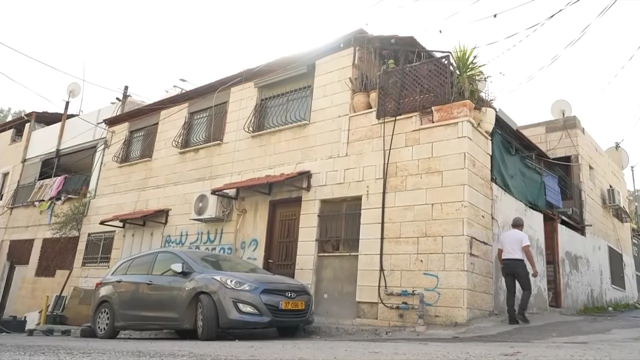 Wohnhaus und Straße in Ost-Jerusalem mit geparktem Auto und Fußgänger