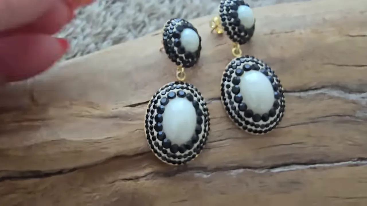 pair of black and white drop earrings on a wooden surface
