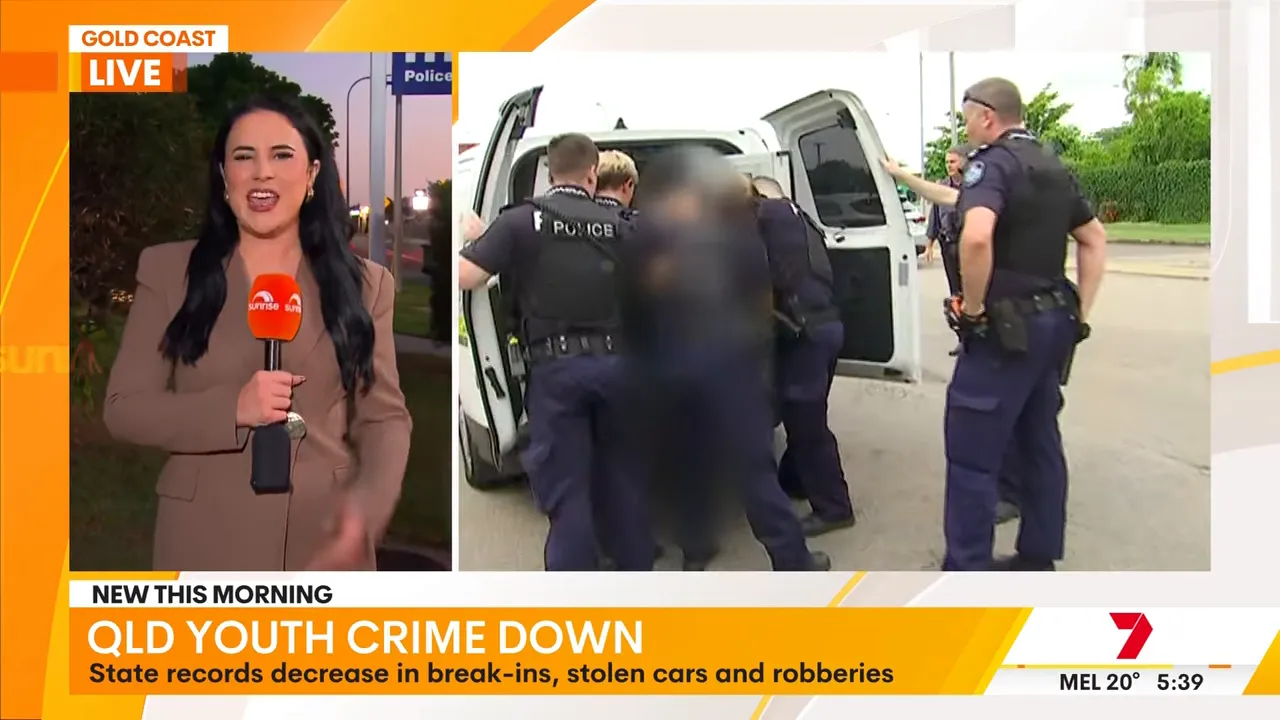 Police officers escorting someone near a police vehicle during Queensland crime news segment