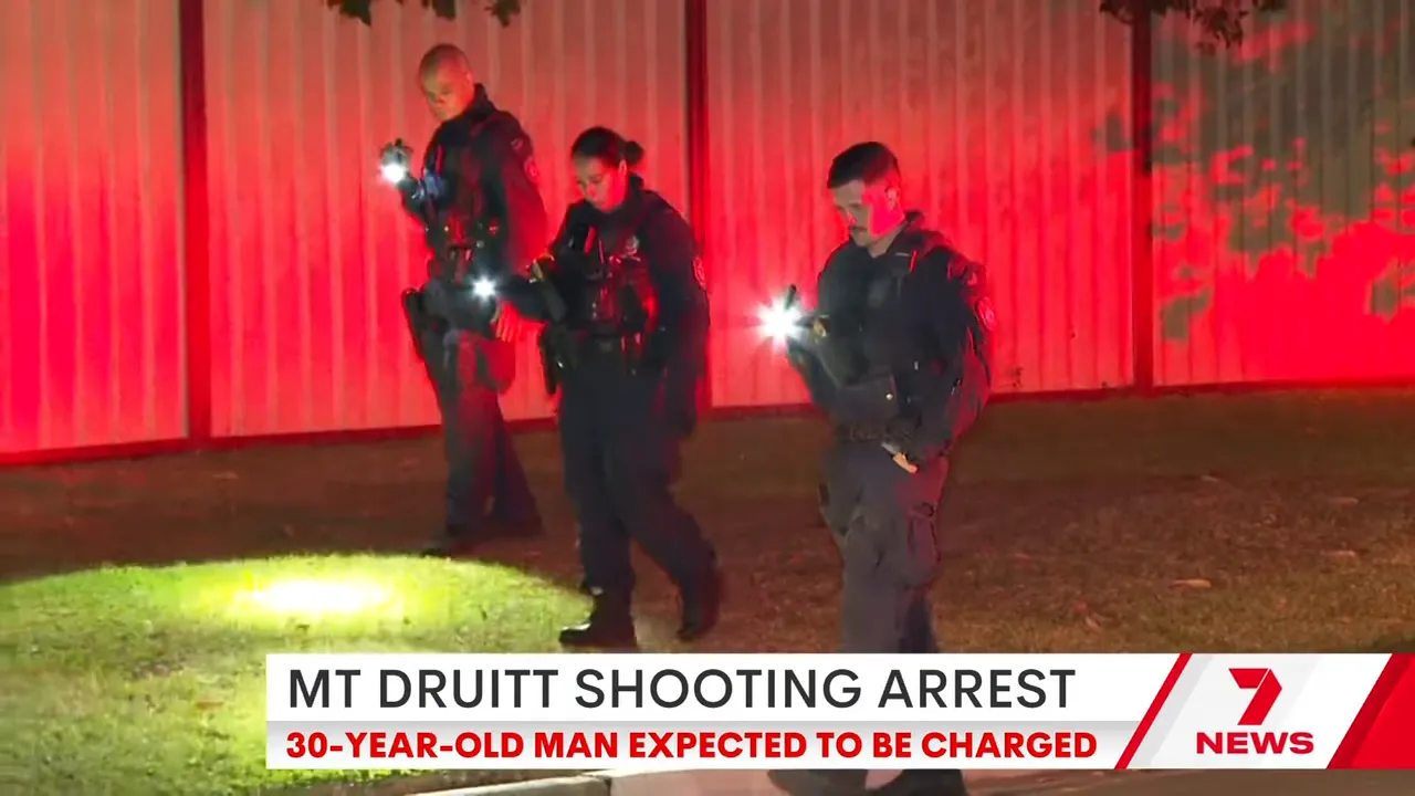 Police officers searching a yard at night with torches and a news chyron reading 'MT DRUITT SHOOTING ARREST'.
