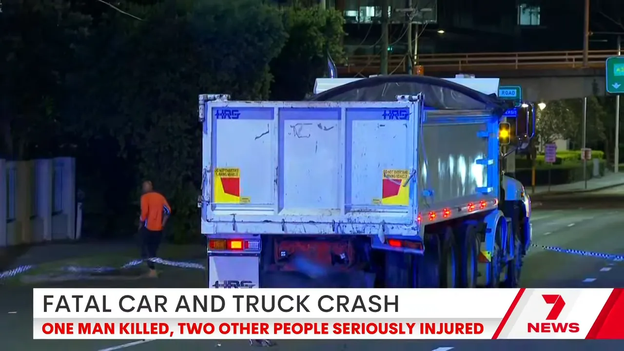 Rear of a truck at a nighttime crash scene with police tape and a person nearby