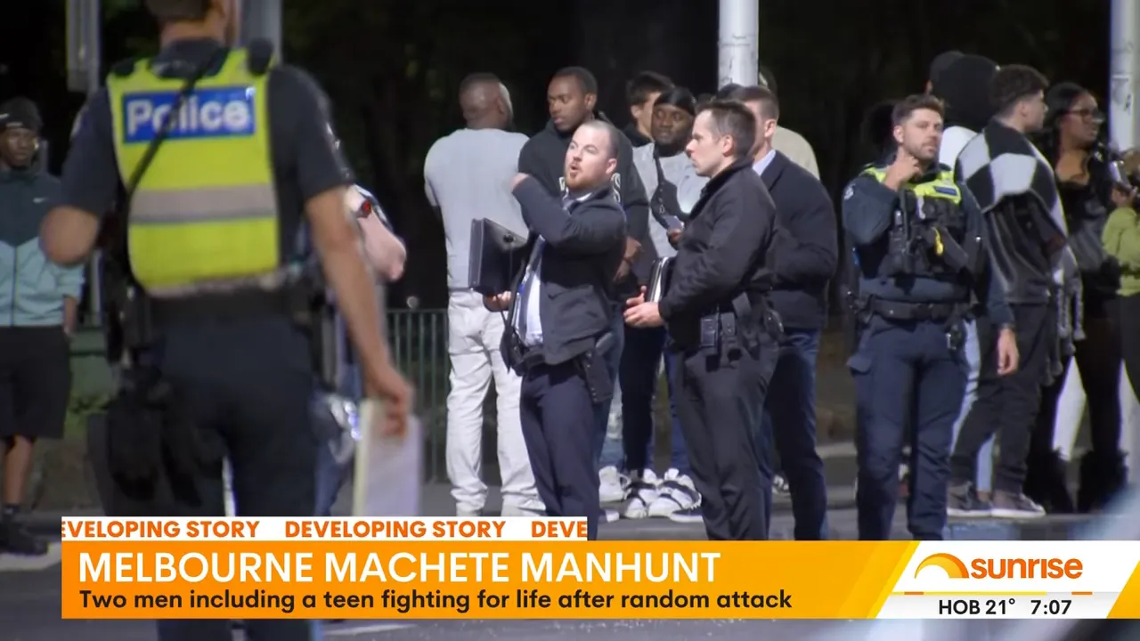 Nighttime image of multiple police officers and investigators grouped behind a police cordon on Lygon Street.