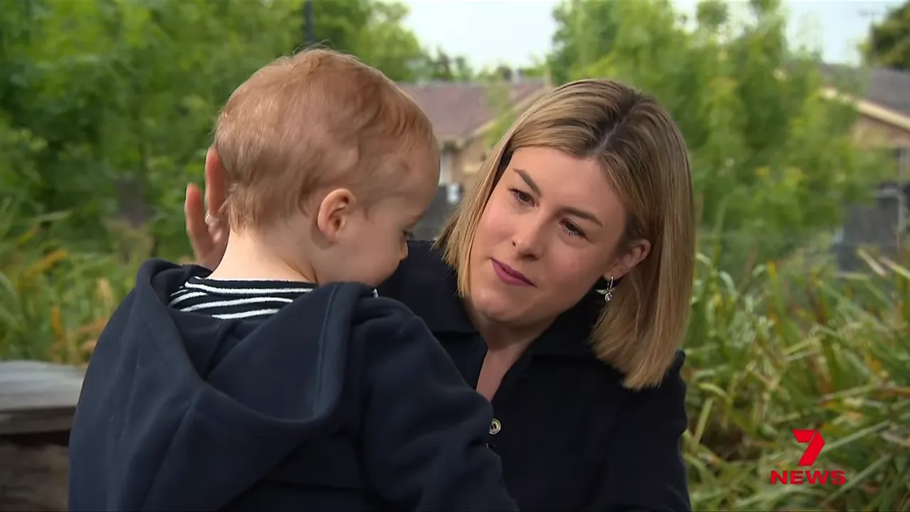 Politician holding and looking at her toddler during an outdoor interview