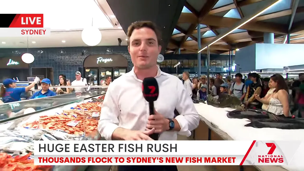 Reporter in front of seafood display at Sydney Fish Market during Easter trading