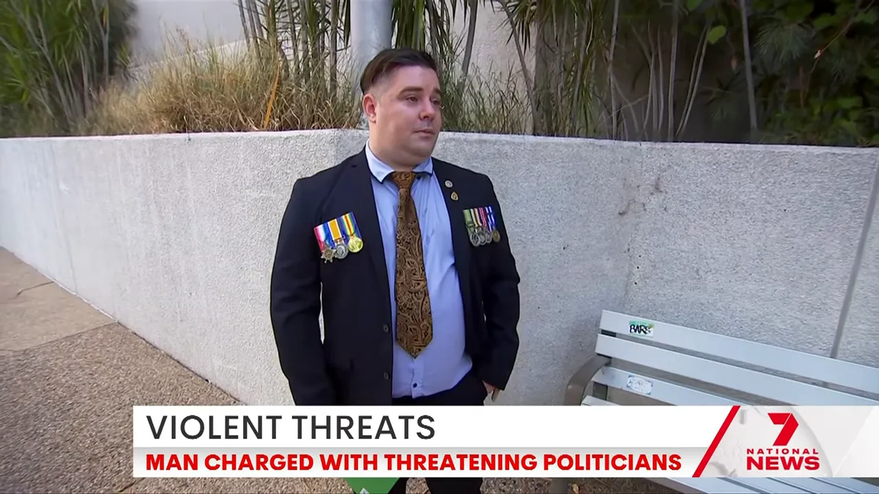 Man in a suit wearing service medals standing next to a bench outside a building with a news chyron reading 'VIOLENT THREATS'.